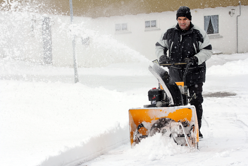 Schneeräumen mit einer Schneefräse - Ein Mann räumt Schnee